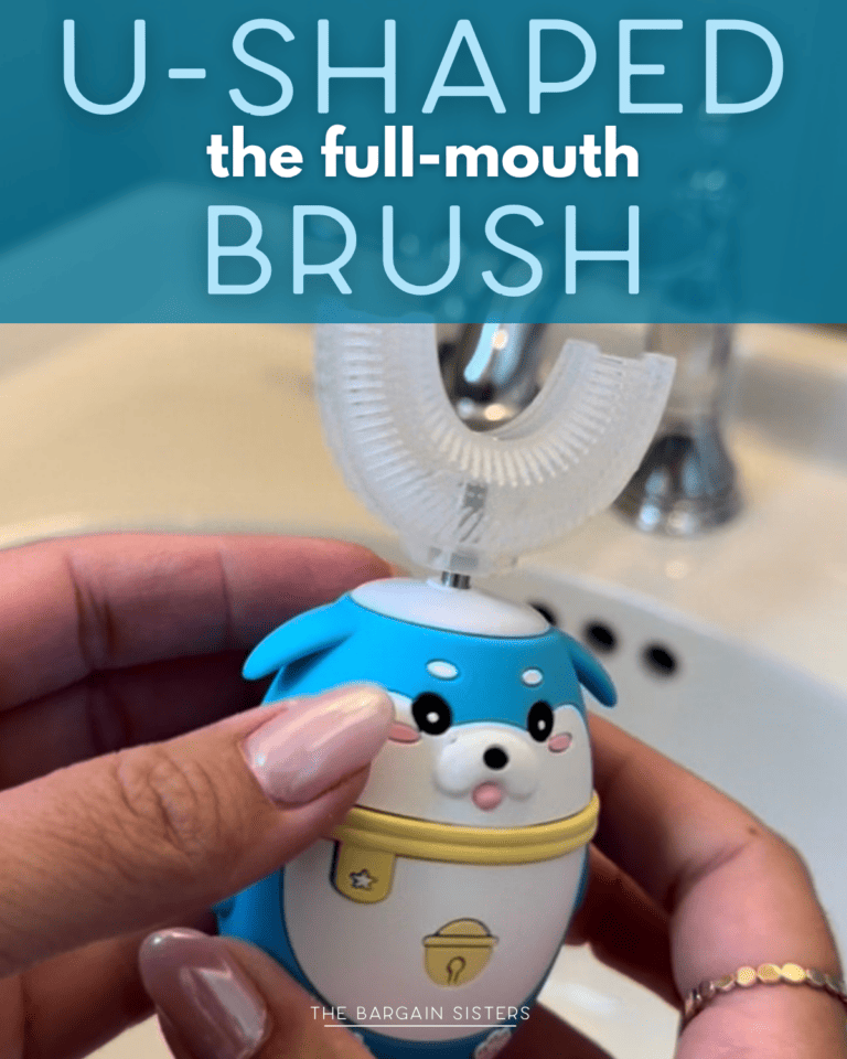 A person holds a cute, blue U-shaped full-mouth toothbrush shaped like a seal, in front of a bathroom sink.