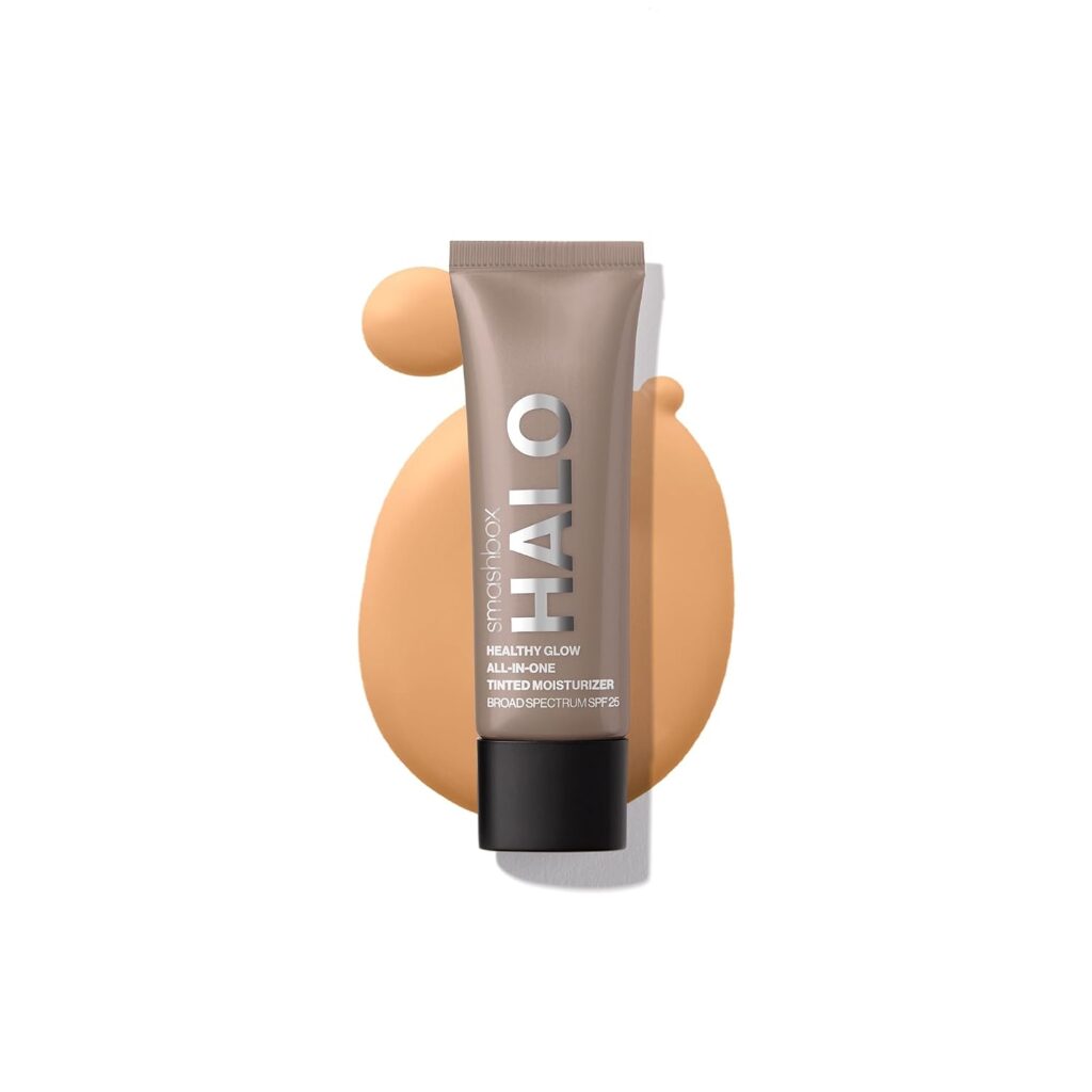 A tube of Smashbox Halo tinted moisturizer SPF 25 lies on a swatch of beige product against a white background.