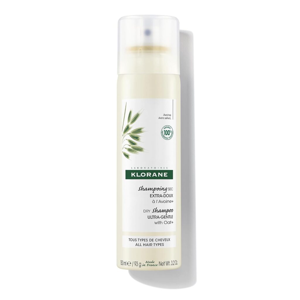 A can of Klorane Dry Shampoo with Oat Milk for all hair types, featuring a white and beige design with a green oat graphic and product information in French and English.