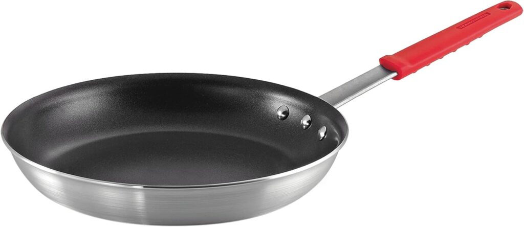 A nonstick frying pan with a black interior and a red heat-resistant handle, shown on a white background.