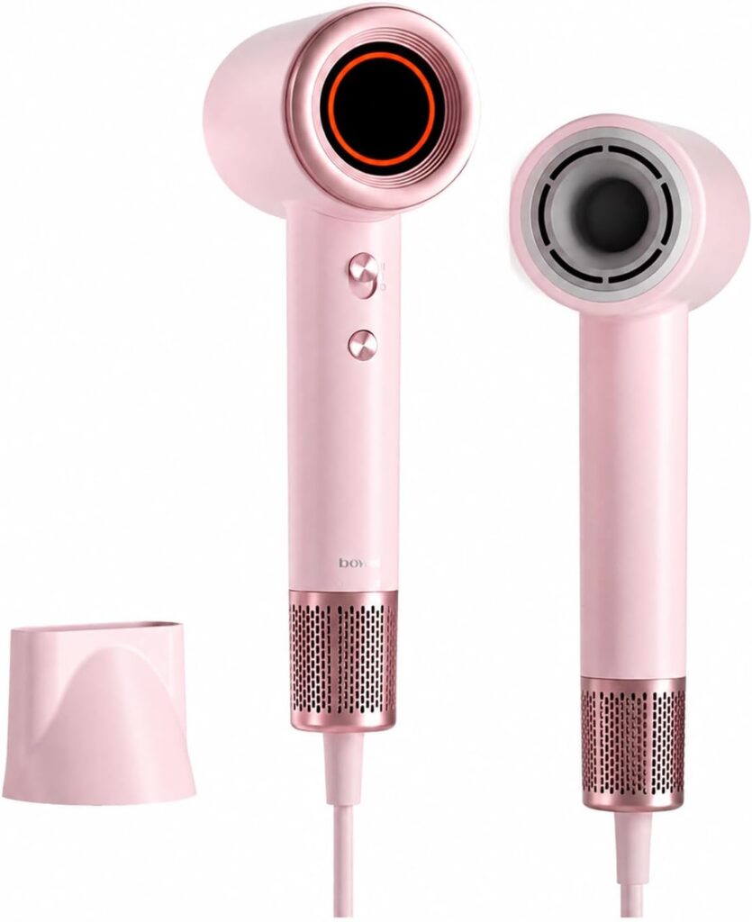 Two pink hair dryers are shown, one facing forward and one to the side. Both have a modern design with a cylindrical shape and vented ends. A pink attachment or cap is placed beside them.