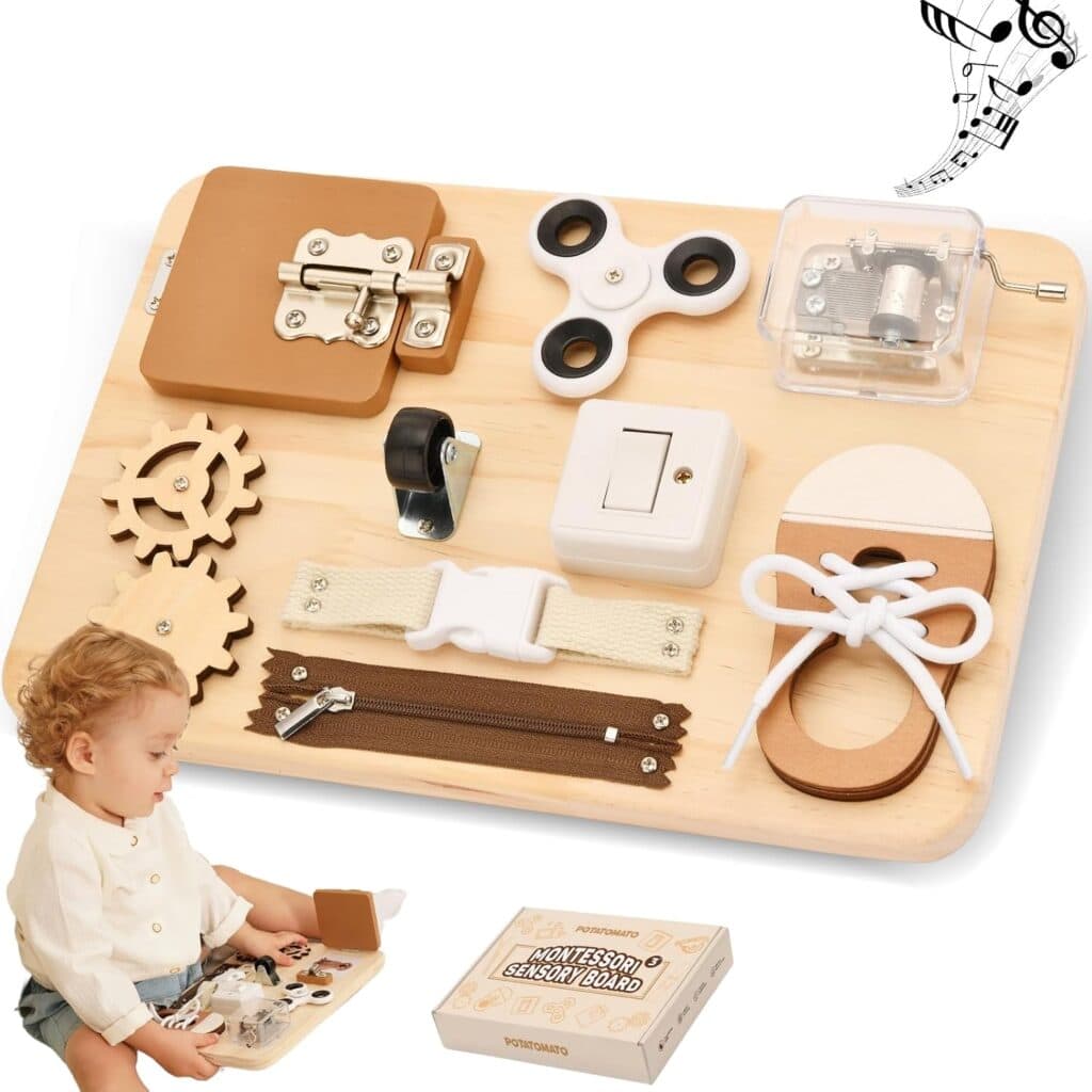 A toddler plays with a wooden sensory activity board featuring gears, latch, zipper, fidget spinner, buckle, switch, lock, and shoelace, with a toy box and a music note illustration nearby.