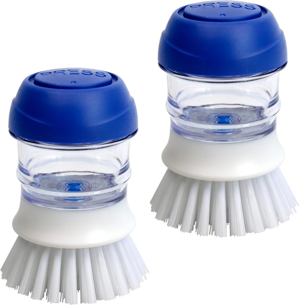 Two round dish scrub brushes with clear bodies, blue push-button tops labeled "PRESS," and white bristles, shown on a white background.