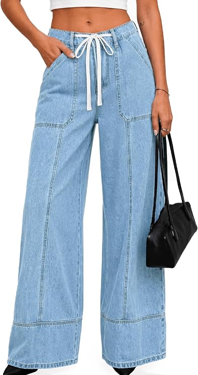 Woman wearing light blue wide-leg jeans with front pockets, a white drawstring waist, white crop top, and holding a black handbag. Only her body is visible, not her face.