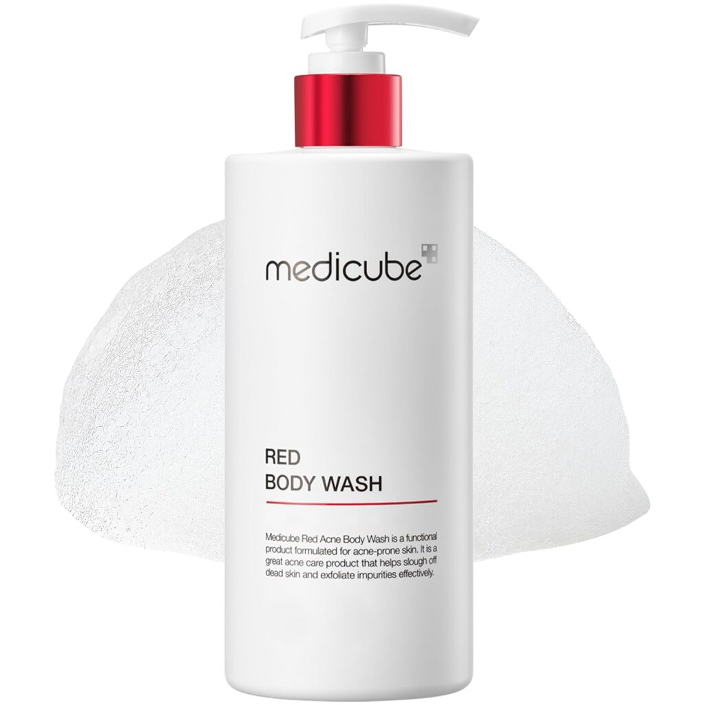 A white pump bottle labeled "medicube RED BODY WASH" stands in front of a background featuring a mound of white foam.
