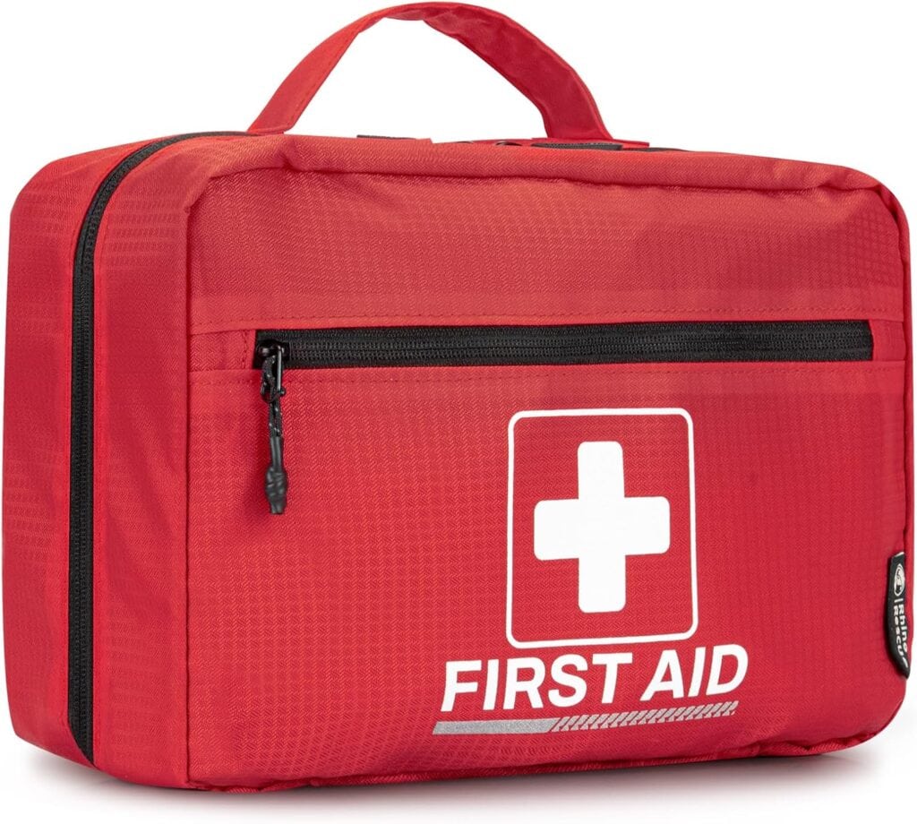 A red first aid kit bag with a white cross and the words "FIRST AID" printed on the front. The bag has a black zipper pocket on the front and a carrying handle on top.