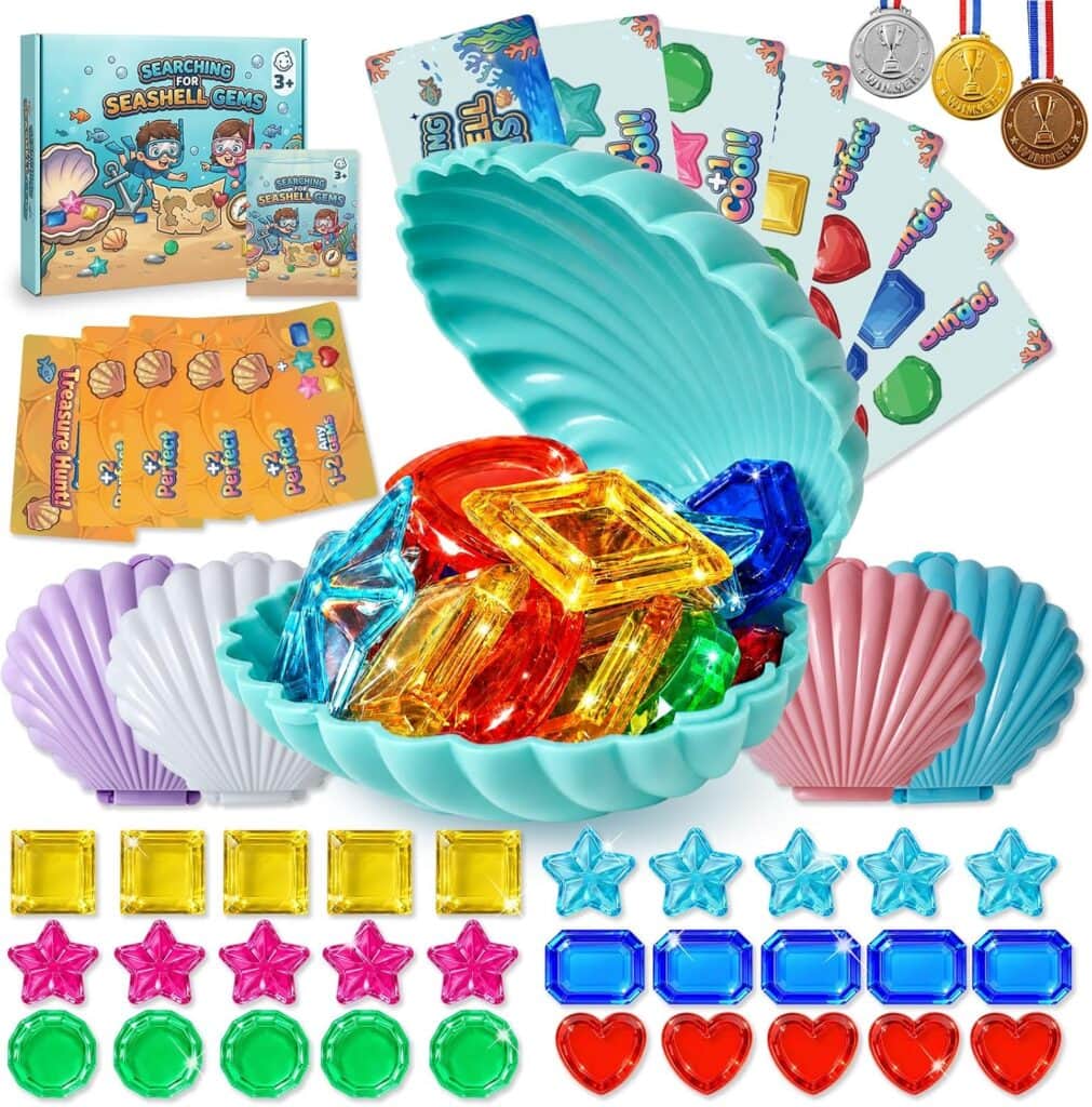A colorful game set with plastic seashells, jewel-shaped gems, cards, envelopes, medals, and a blue shell container filled with red, yellow, blue, and green gems, arranged on a white background.