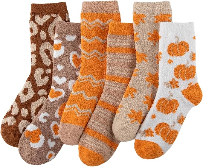 Six pairs of fuzzy socks in brown, orange, and cream colors, each with different patterns including animal print, hearts, zigzags, stripes, leaves, and pumpkins.