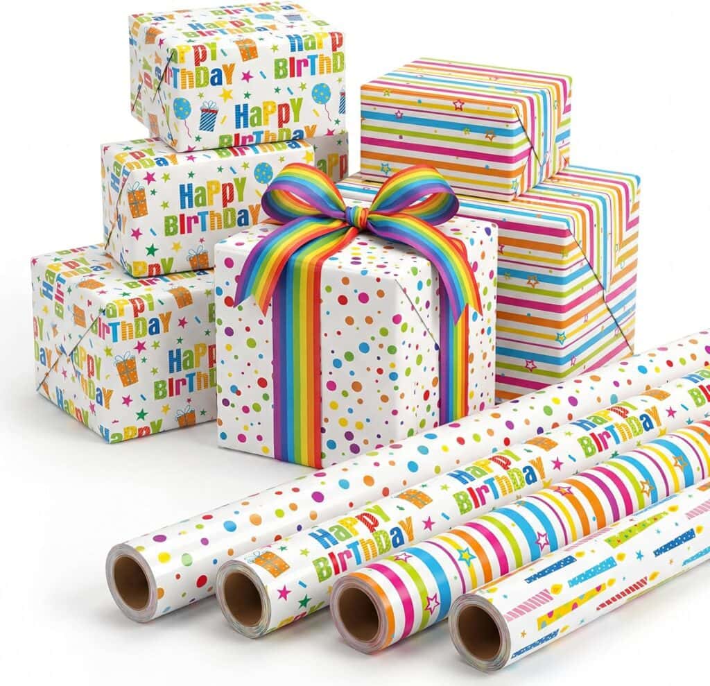 Five wrapped birthday presents with colorful patterns—dots, stripes, stars, and "Happy Birthday" text—sit behind four matching rolls of wrapping paper. One gift is tied with a rainbow-striped ribbon.