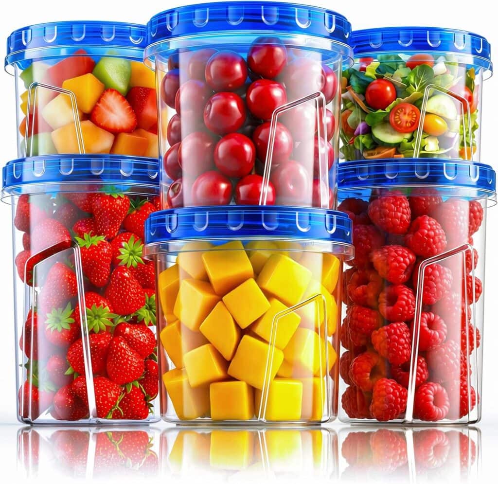 Six clear freezer storage containers with blue lids, each filled with fresh produce: strawberries, diced mango, red cherries, raspberries, a salad with cucumber and tomatoes, and mixed fruit pieces.