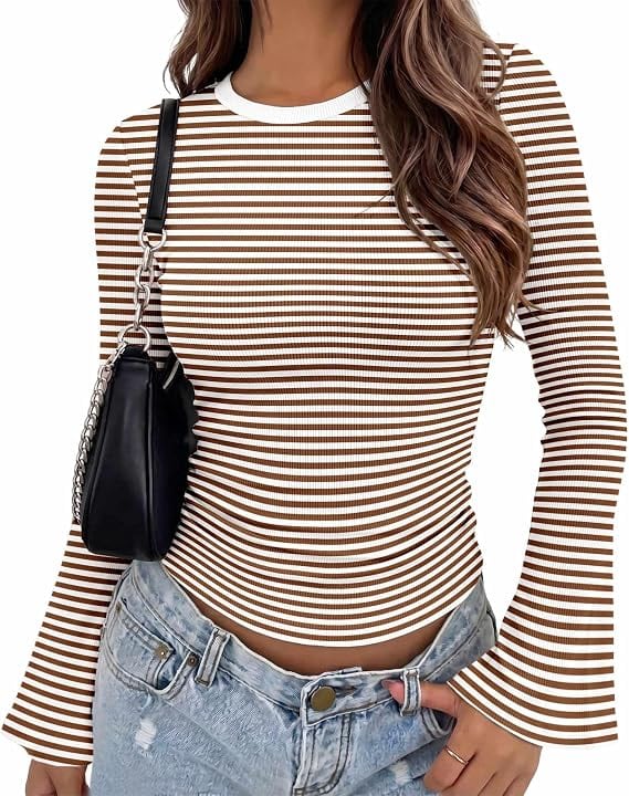 Woman wearing a brown and white striped long-sleeve top with flared cuffs, light-wash jeans, and a black shoulder bag. Only the upper body is visible.