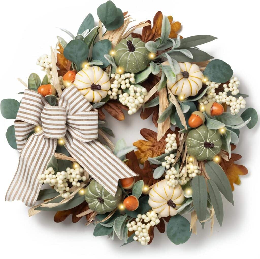 A festive wreath with white and green pumpkins, orange berries, white berries, green leaves, brown foliage, raffia, and a striped bow, arranged in a circular pattern.