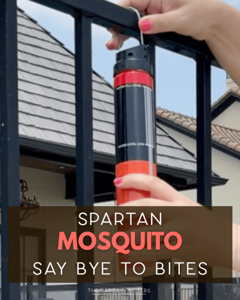 A person hangs a red canister labeled "Spartan Mosquito" on a black metal fence, right next to a handy Bowl and Colander Set. The text overlay says, "Spartan Mosquito Say Bye to Bites." Houses are visible in the background.