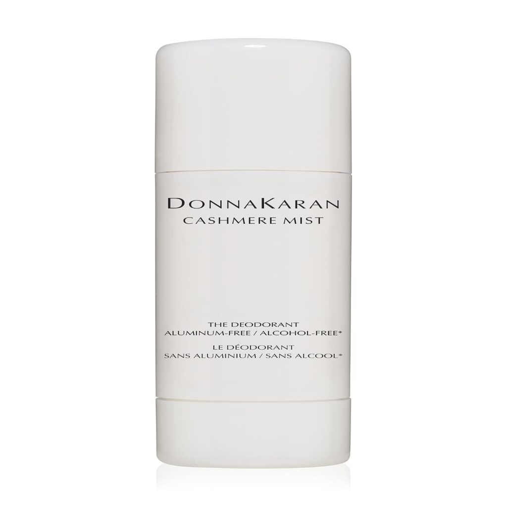 A white cylindrical bottle of Donna Karan Cashmere Mist deodorant, labeled as aluminum-free and alcohol-free. The text is printed in black on the front of the bottle.