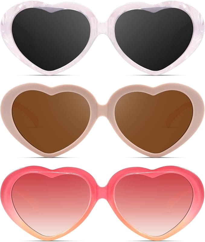 Three pairs of heart-shaped sunglasses in different colors: black with a light frame, brown with a beige frame, and pink with a red-pink gradient frame, all displayed on a white background.