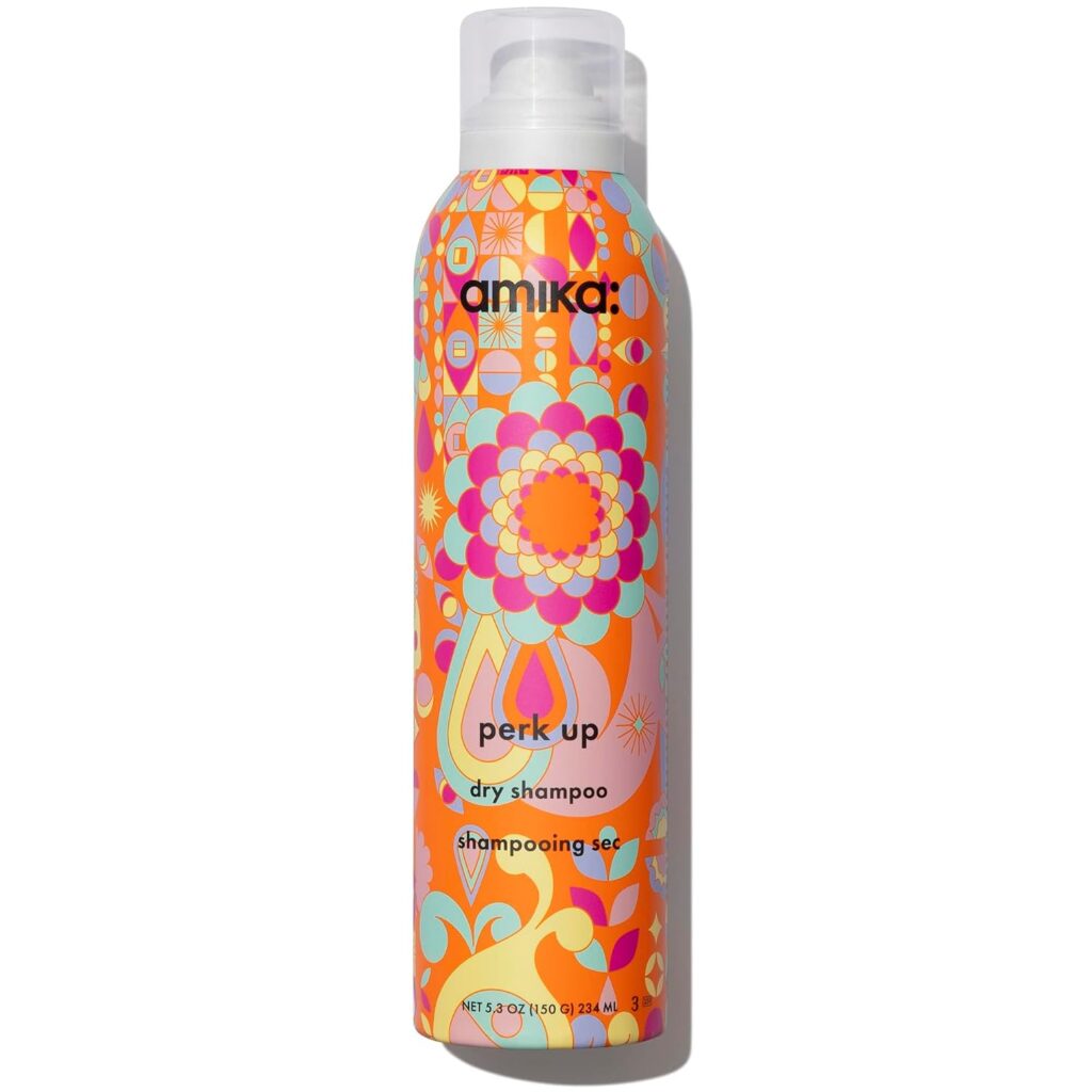 A colorful canister of Amika Perk Up Dry Shampoo with a vibrant, psychedelic floral pattern and white cap. The text and logo are displayed on the front of the can.