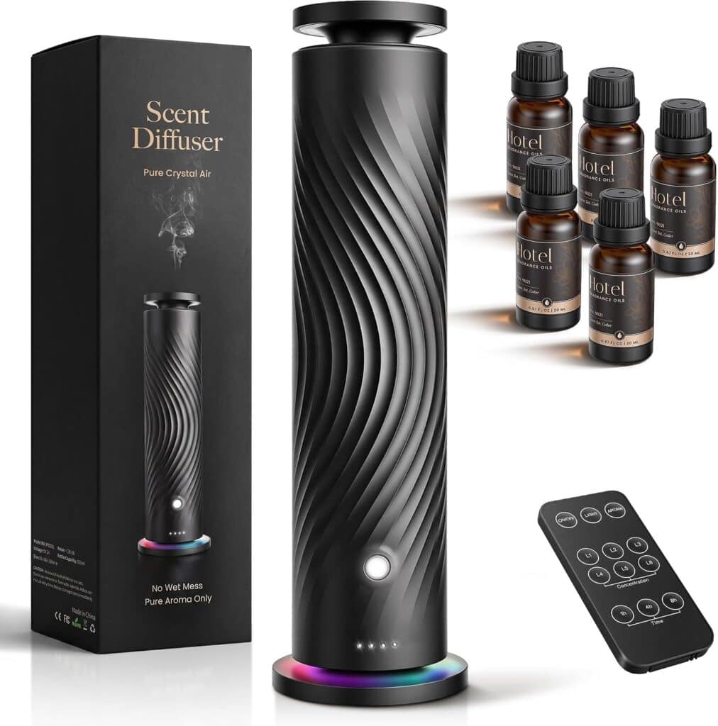 Tall black scent diffuser with wavy design, next to its box, remote control, and five small essential oil bottles with brown labels, all arranged on a plain white background.