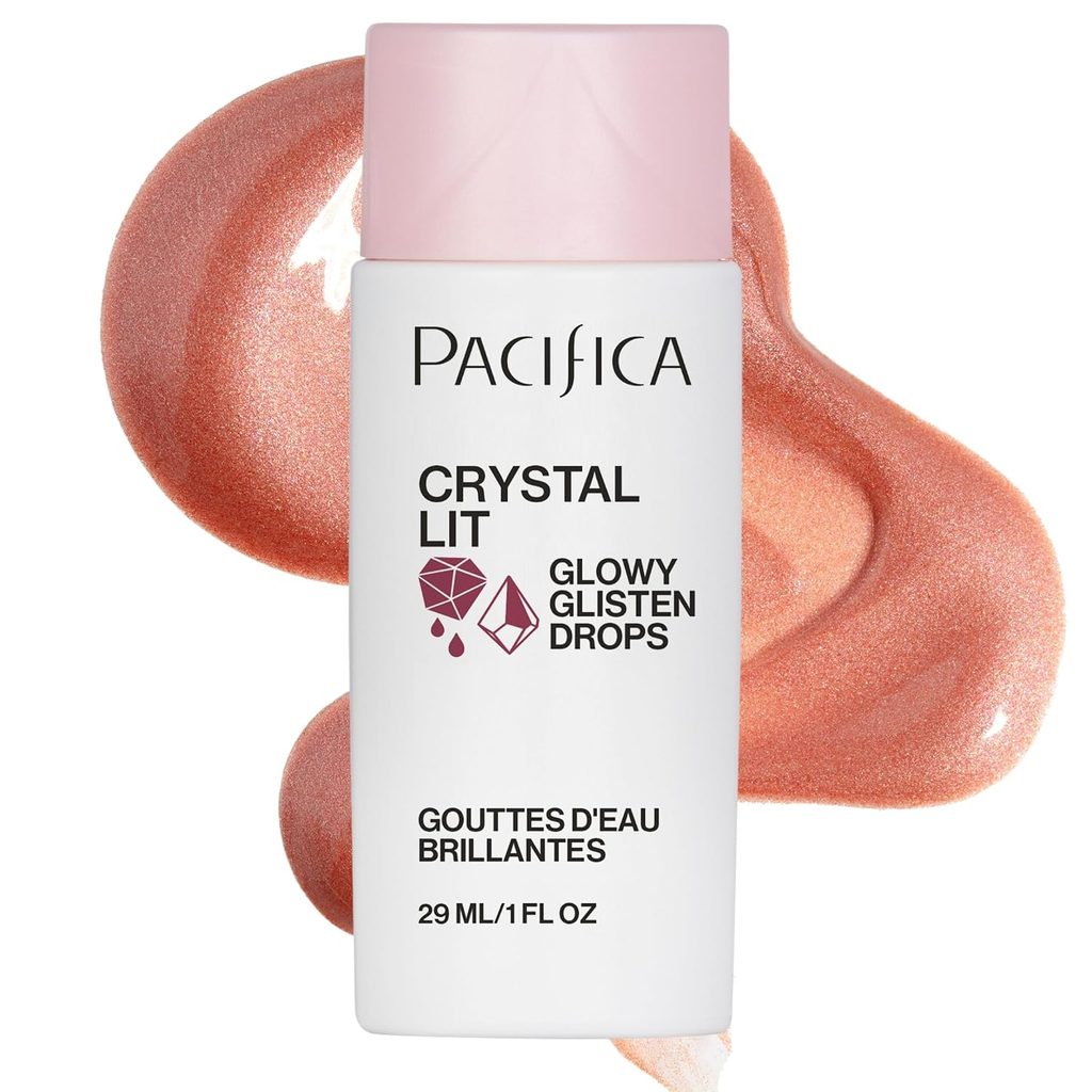 A bottle of Pacifica Crystal Lit Glowy Glisten Drops lies in front of a spill of shimmery rose-gold liquid. The bottle is white with a pink cap and black text describing the product.
