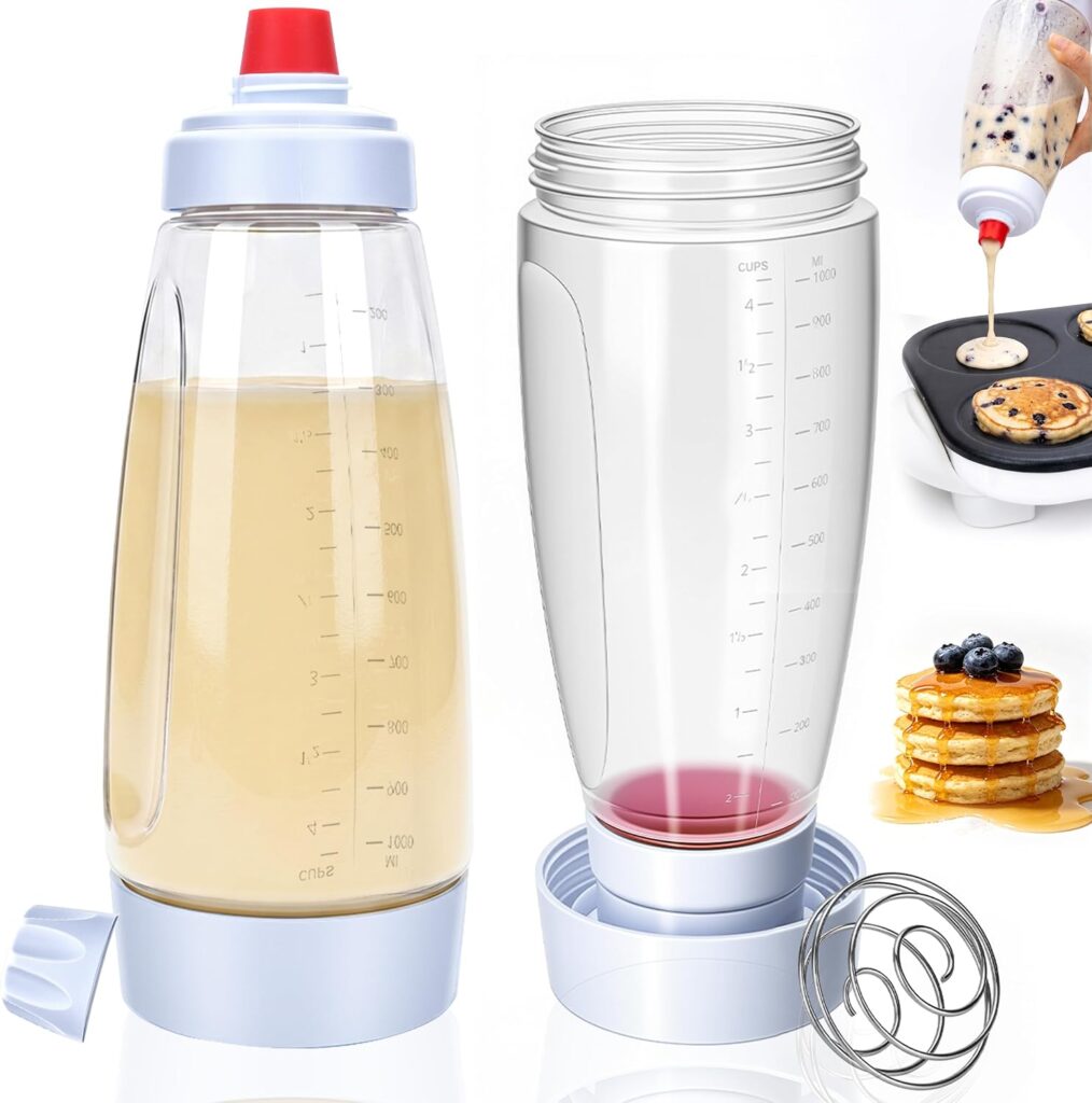 Two clear batter dispenser bottles with measurement markings, metal mixing balls, and blue lids. One filled with batter, one partly filled with liquid. Pancakes are being made and stacked with berries in the background—these 2PCS pancake bottles make preparing breakfast quick and mess-free.