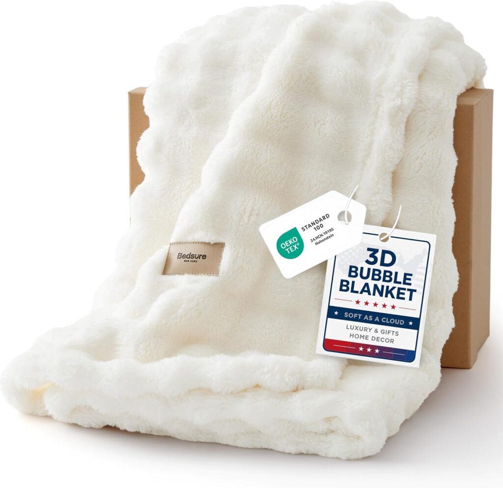 A fluffy white Bedsure 3D Bubble Blanket draped over a brown box, with tags describing it as soft, luxurious, and OEKO-TEX certified.
