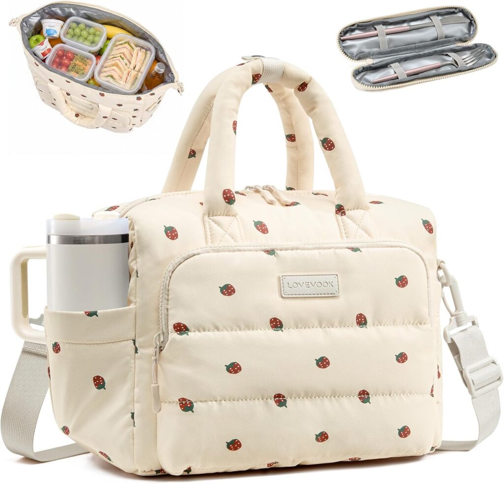 Beige insulated lunch bag with strawberry print, front pocket, side drink holder, top handles, and shoulder strap. Inset shows packed lunch inside and two rolled-up utensil cases.