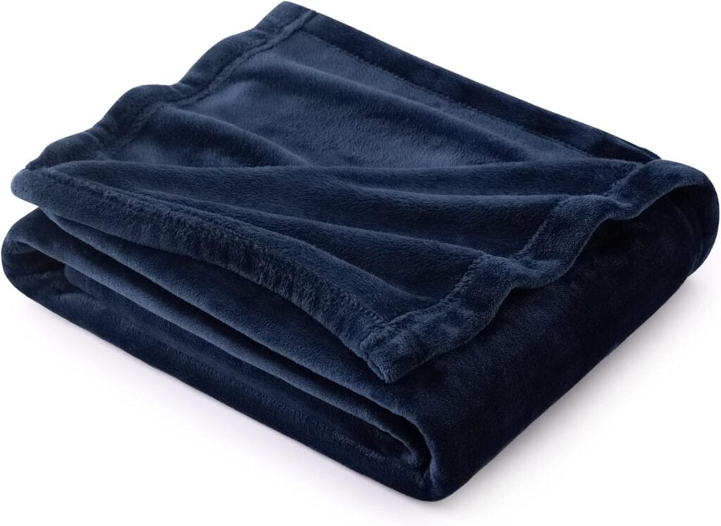 A neatly folded navy blue plush blanket with soft, velvety texture is shown against a white background.