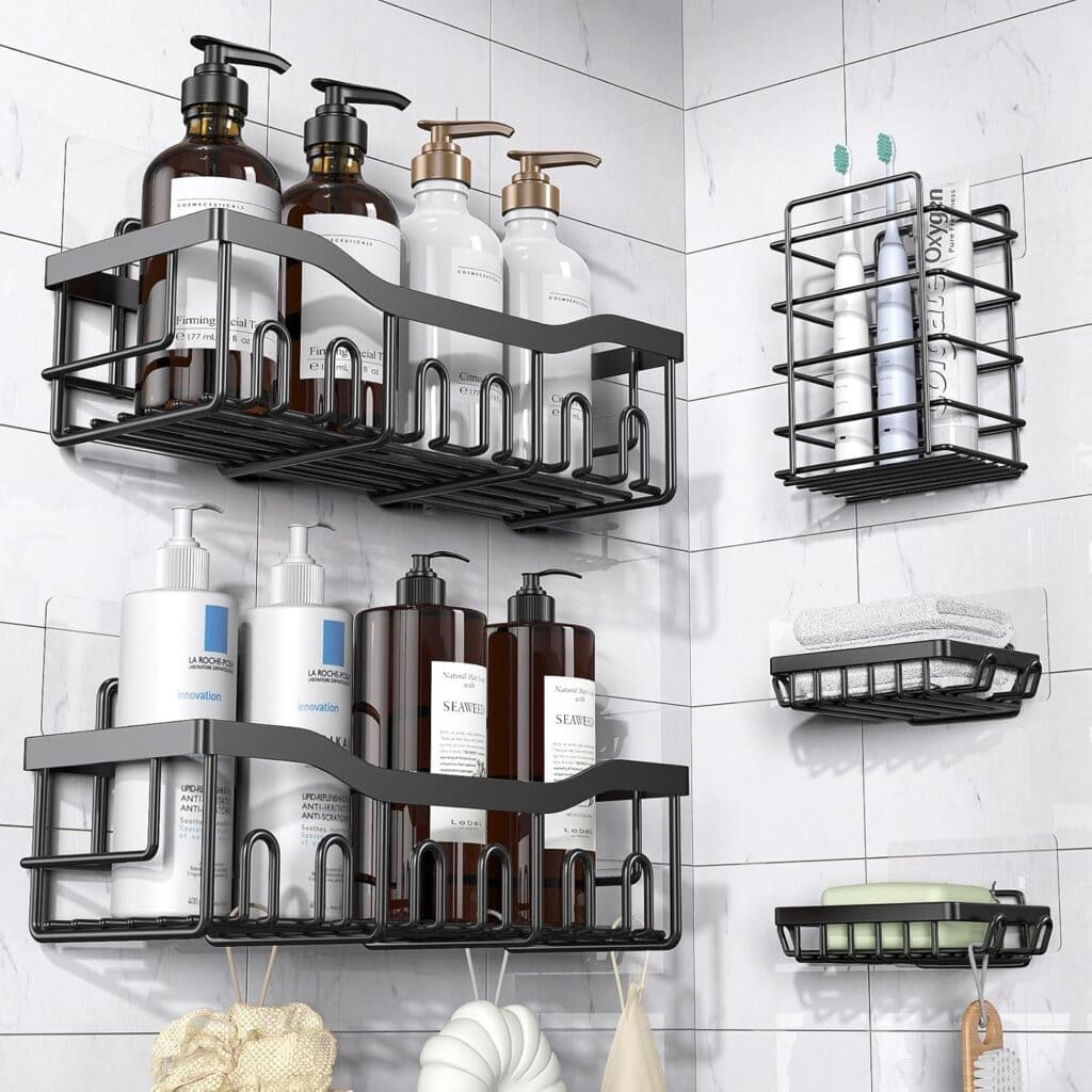 Four black metal shower shelves hold bottles, soap, toothbrushes, and towels against a white tiled bathroom wall, organized neatly in a corner.