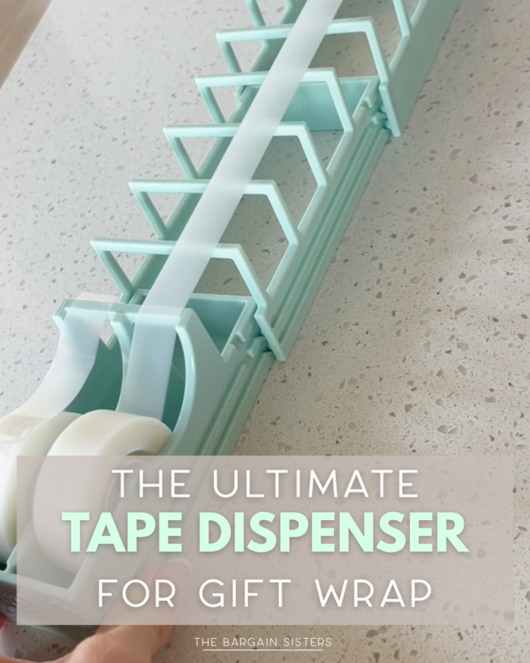A hand pulls tape from a large, light blue tape dispenser holding two rolls, designed for gift wrapping. Text overlay reads: “The Ultimate Tape Dispenser for Gift Wrap.”.