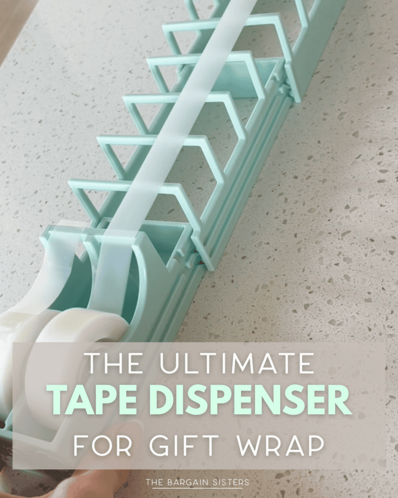 A hand pulls tape from a large, light blue tape dispenser holding two rolls, designed for gift wrapping. Text overlay reads: “The Ultimate Tape Dispenser for Gift Wrap.”.