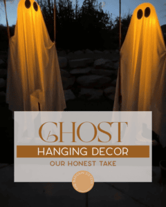 Two glowing ghost decorations hang outdoors at dusk, draped in white sheets with black eyes. Text overlay reads, “Ghost Hanging Decor: Our Honest Take. The Bargain Sisters.”.