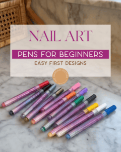 Twelve glittery nail art pens in various colors are arranged on a marble surface, with text overlay: “Nail Art Pens for Beginners - Easy First Designs.”.