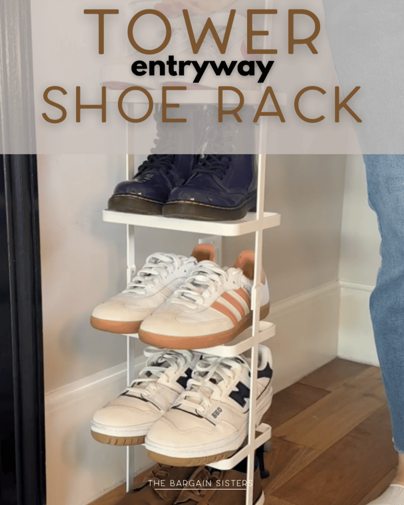 A three-tier white shoe rack in an entryway holds various pairs of sneakers and boots. The rack is placed on a wooden floor near a black door. Text reads “Tower entryway shoe rack.”.