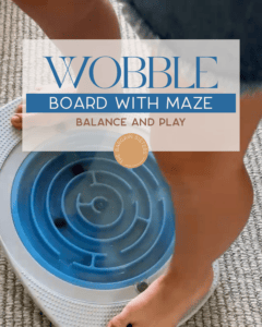 A person standing on a blue balance board with a maze design, moving small black balls through the maze. Text overlay reads, “Wobble Board with Maze - Balance and Play.”.